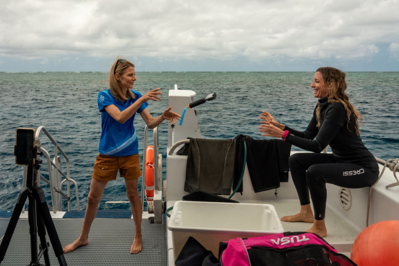 JCU Senior Researcher Katie Chartrand passes a GoPro to Master Reef Guide Michelle Barry. Credit_Brad Fisher